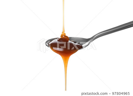 Pouring salted caramel into spoon isolated on white 97804965