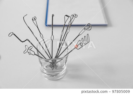 Set of different logopedic probes in holder on light table. Speech therapist's tools 97805009