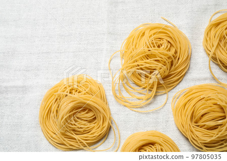 Capellini pasta on white tablecloth, flat lay Capellini pasta on white tablecloth, flat lay 97805035