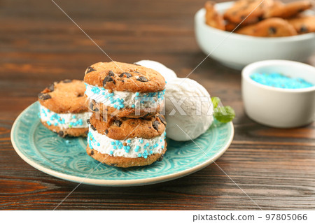 Sweet delicious ice cream cookie sandwiches on wooden table 97805066