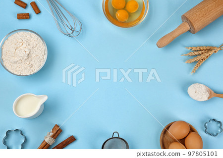 Flat lay composition with raw eggs and other ingredients on light blue background, space for text. Baking pie 97805101