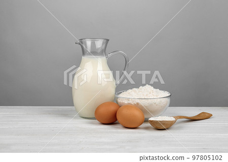 Raw eggs and other ingredients on white wooden table. Baking pie Raw eggs and other ingredients on white wooden table. Baking pie 97805102