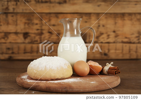 Raw eggs and other ingredients on wooden table. Baking pie Raw eggs and other ingredients on wooden table. Baking pie 97805109