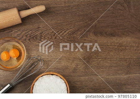 Flat lay composition with raw eggs and other ingredients on wooden table, space for text. Baking pie Flat lay composition with raw eggs and other ingredients on wooden table, space for text. Baking pie 97805110