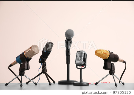 Different microphones on light grey table. Journalist's work Different microphones on light grey table. Journalist's work 97805130