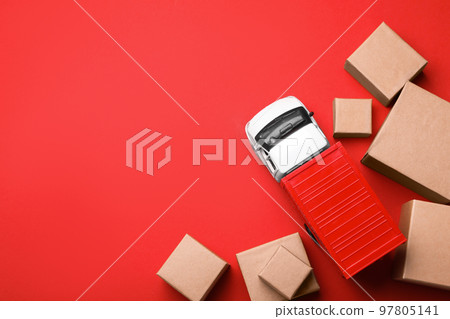 Top view of toy truck with boxes on red background. Logistics and wholesale concept Top view of toy truck with boxes on red background. Logistics and wholesale concept 97805141