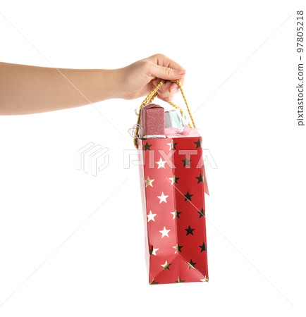 Woman holding shopping paper bag with presents on white background, closeup Woman holding shopping paper bag with presents on white background, closeup 97805218