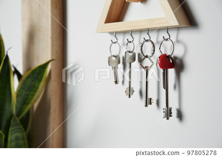 Wooden key holder on light wall indoors 97805278