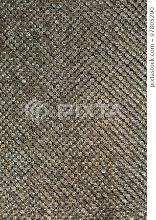 Small gemstone texture background. Background with shining elements on fabric. Holiday abstract glitter background with blinking lights. Fashion metallic 97805290