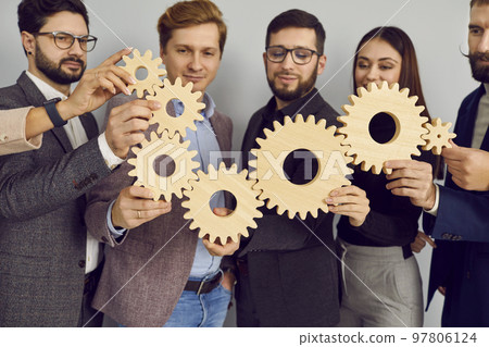Group of business people connecting wooden cogwheels together 97806124