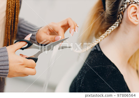 Hairstylist braided afro braids dreadlocks kanekalon pigtails hair of female client in barber salon. Hairstylist braided afro braids dreadlocks kanekalon pigtails hair of female client in barber salon. 97806564
