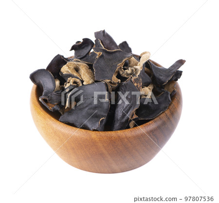 Dry black fungus in wooden bowl, isolated on white background. Chinese black mushroom or tree black muer mushroom. Auricularia polytricha. 97807536