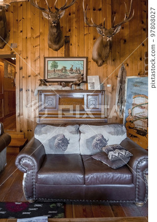 Yellowstone National Park, USA. September 16, 2022. Taxidermy animals mounted over sofa arranged in log cabin. Interior of decorated lobby at heart six ranch in famous Yellowstone national park. 97808027