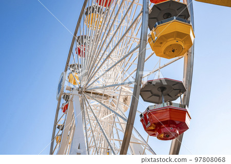 Low angle view of of colorful ferris wheel with clear blue sky in background during summer season at Pacific Park on Santa Monica Pier at Los Angeles Low angle view of of colorful ferris wheel with clear blue sky in background during summer season at Pacific Park on Santa Monica Pier at Los Angeles 97808068