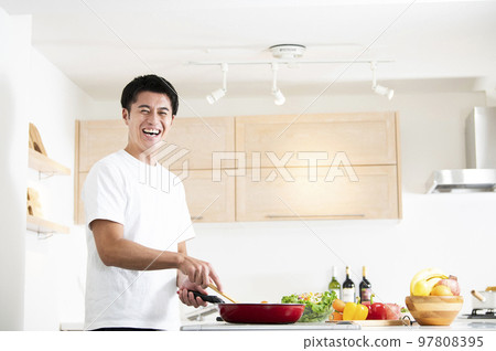 一個男人在做飯,看著鏡頭 一個男人在做飯,看著鏡頭 97808395