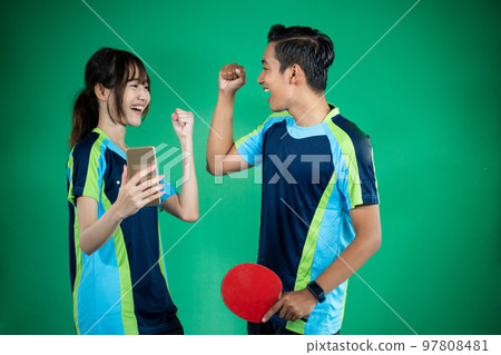 female and male athletes looking at smartphones with clenched fists 97808481