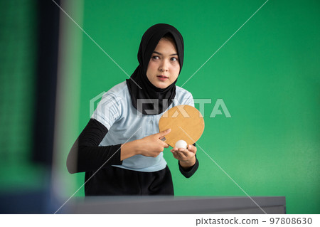 Muslim female table tennis player holding ball preparing to serve 97808630