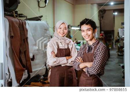 hijabi craftswoman and craftsman smiling with crossed hands hijabi craftswoman and craftsman smiling with crossed hands 97808655