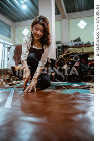 Asian craftswoman working cutting leather on the floor 97808661