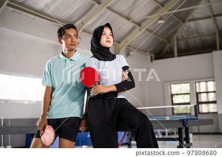 female athlete in hijab and man standing holding bat 97808680