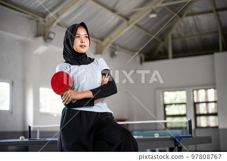female athlete in hijab holding bat with crossed hands female athlete in hijab holding bat with crossed hands 97808767