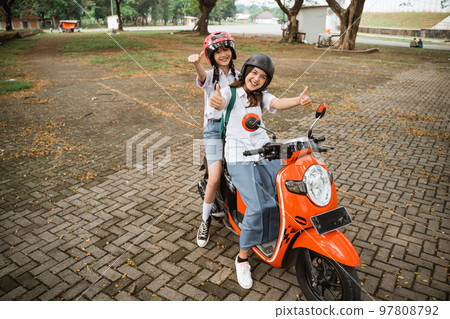 Two asian student girls wearing helmets with thumbs up 97808792