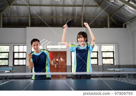 Asian ping pong doubles players excited when they score 97808793
