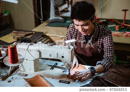 tailor man using sewing machine with table lamp tailor man using sewing machine with table lamp 97808853