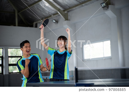 male and female asian ping pong players happy to score 97808885
