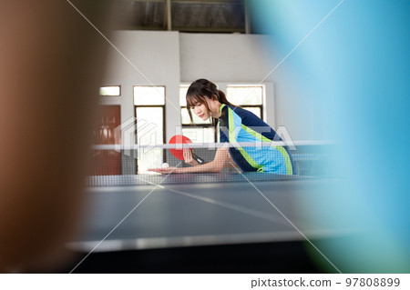 Female athlete holding paddle and ball while serving Female athlete holding paddle and ball while serving 97808899