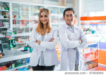 Two asian female and male pharmacists standing smiling Two asian female and male pharmacists standing smiling 97808900
