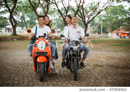 group of high school students riding motorcycle without a helmet group of high school students riding motorcycle without a helmet 97808902