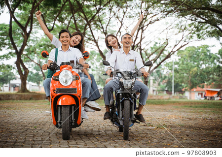 group of high school students celebrating graduation by motorbike 97808903
