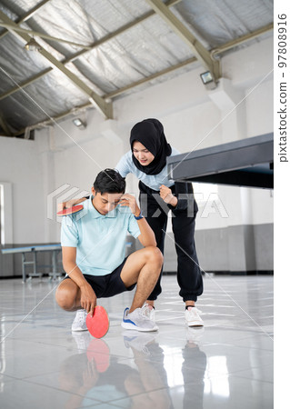 female athlete in hijab encouraging male partner disappointed female athlete in hijab encouraging male partner disappointed 97808916