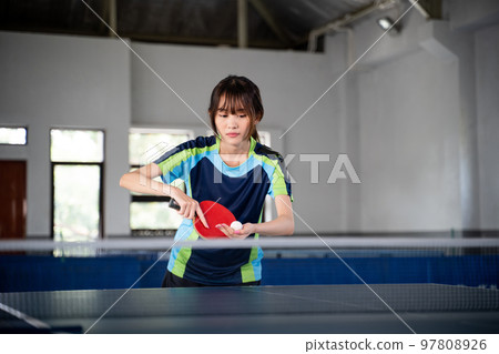 female ping pong athlete holding ball preparing to serve female ping pong athlete holding ball preparing to serve 97808926