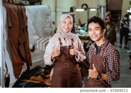 hijabi craftswoman and craftsman smiling with thumbs up hijabi craftswoman and craftsman smiling with thumbs up 97809013
