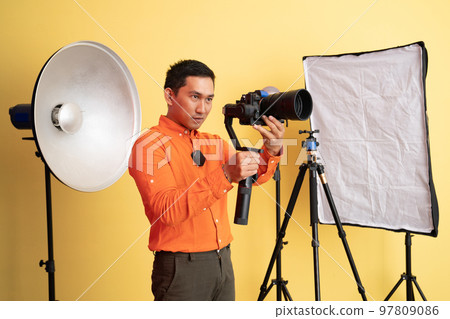 vlogger standing taking photo using professional camera with stabilizer vlogger standing taking photo using professional camera with stabilizer 97809086