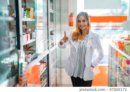 Attractive pharmacist woman in uniform smiling with thumbs up Attractive pharmacist woman in uniform smiling with thumbs up 97809172