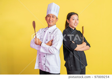 male and female chefs with spatulas while hands crossed 97809254