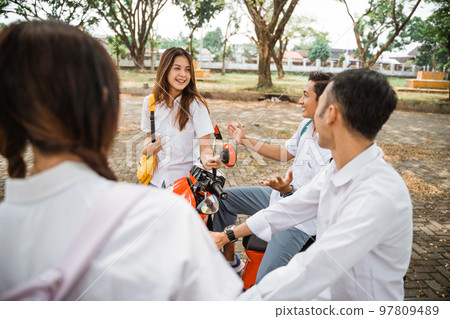 Group of Asian high school students chatting on a motorbike 97809489