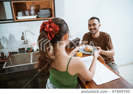 husband is given a plate of food by his wife husband is given a plate of food by his wife 97809700