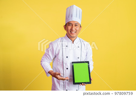 male chef wearing chef jacket showing blank tablet screen male chef wearing chef jacket showing blank tablet screen 97809759