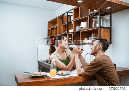 happy couple holding hands while chatting after dinner happy couple holding hands while chatting after dinner 97809792