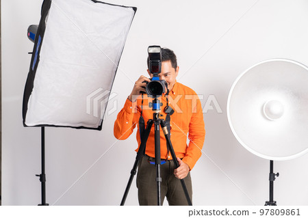 photographer holding camera ready to take photo with lighting equipment photographer holding camera ready to take photo with lighting equipment 97809861