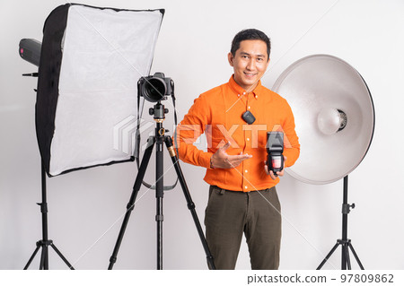 young man holding camera flash with hand gesture pointing young man holding camera flash with hand gesture pointing 97809862