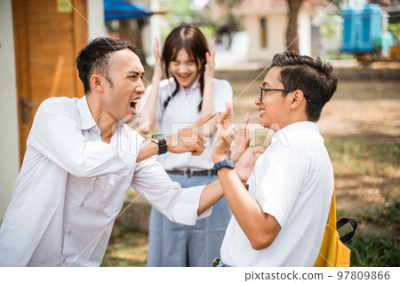 Two male high school students fighting with scared girl screaming Two male high school students fighting with scared girl screaming 97809866