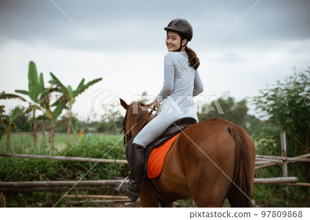 beautiful woman equestrian athlete practicing horse riding on outdoor background beautiful woman equestrian athlete practicing horse riding on outdoor background 97809868