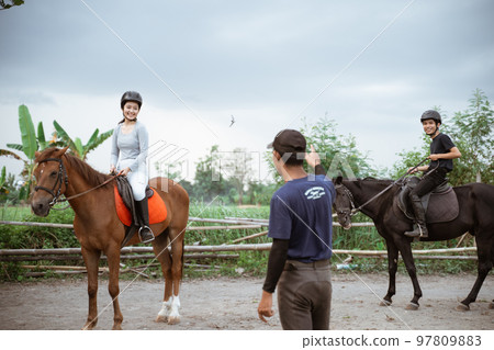 two equestrian athletes riding horses listening to trainer standing guide two equestrian athletes riding horses listening to trainer standing guide 97809883