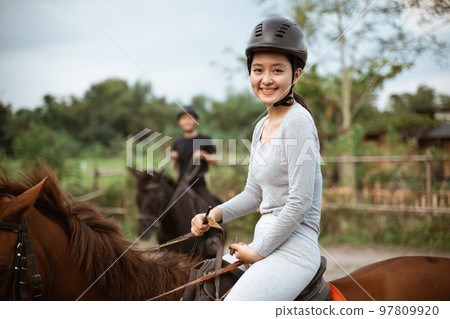 female athlete riding horse to train with male athlete female athlete riding horse to train with male athlete 97809920