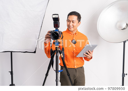 vlogger standing setting camera and holding tablet with lighting equipment 97809930